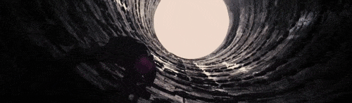 A scene of Batman climbing out of a hole