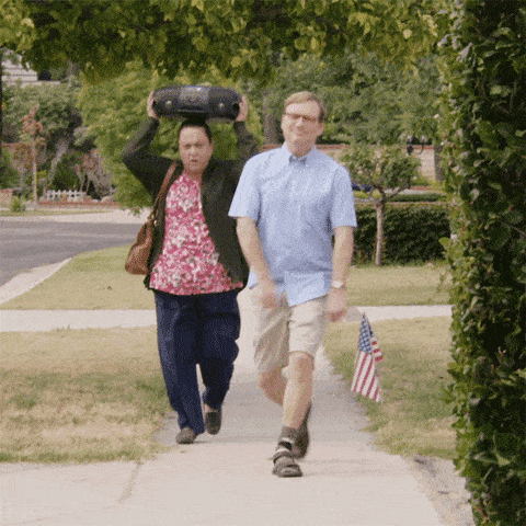 Man skipping followed by woman holding a boombox