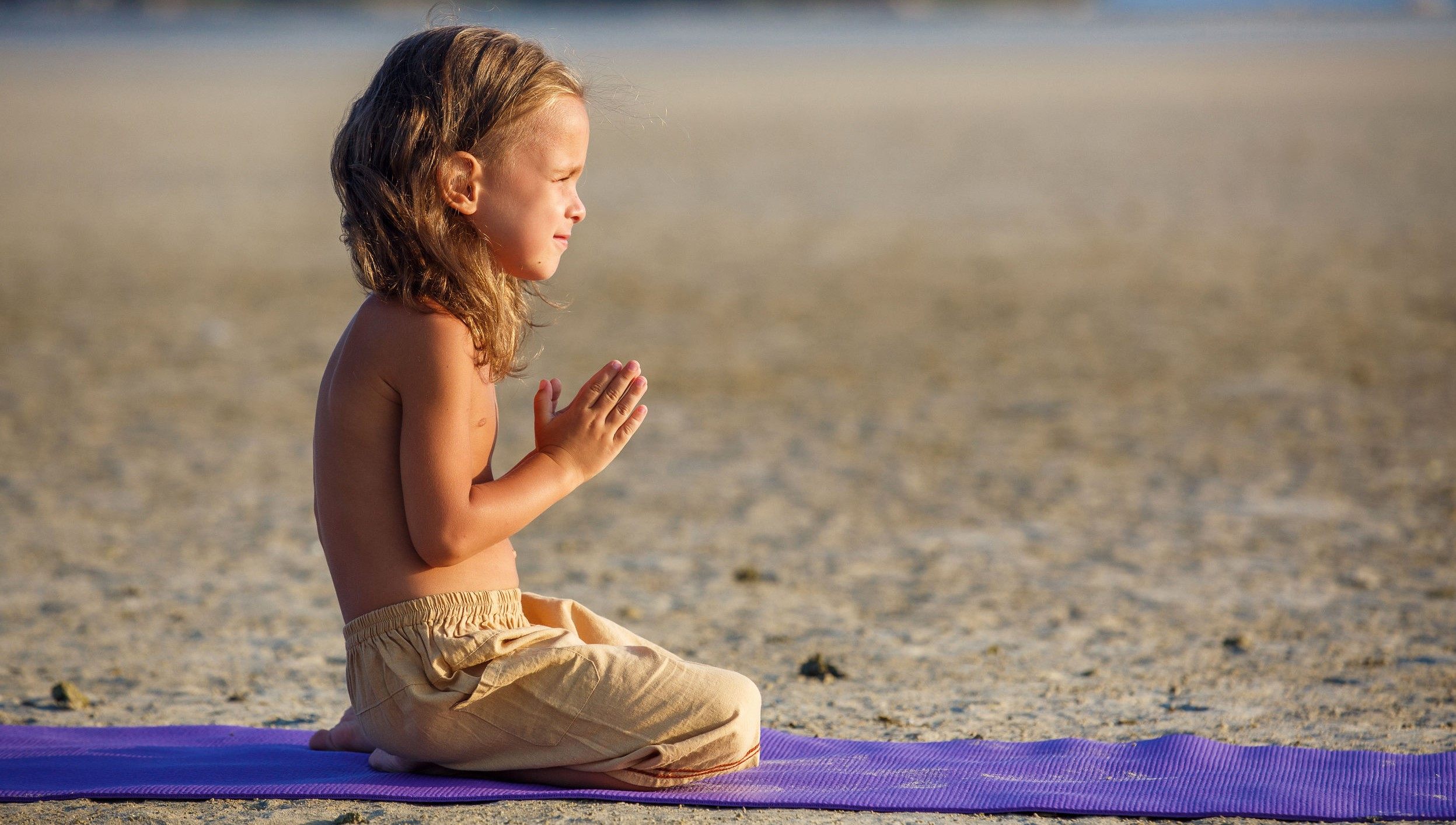 Boy on the beach doing yoga