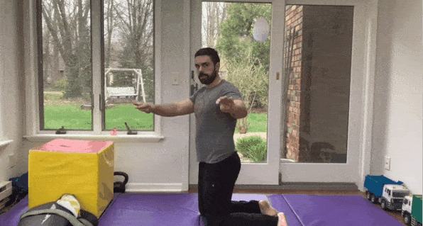 Coach Matt taking his left arm "low " behind him, and his right arm "high" behind him, for this flexibility exercise.