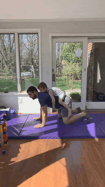 Coach Matt crawling around with his kid on his back.