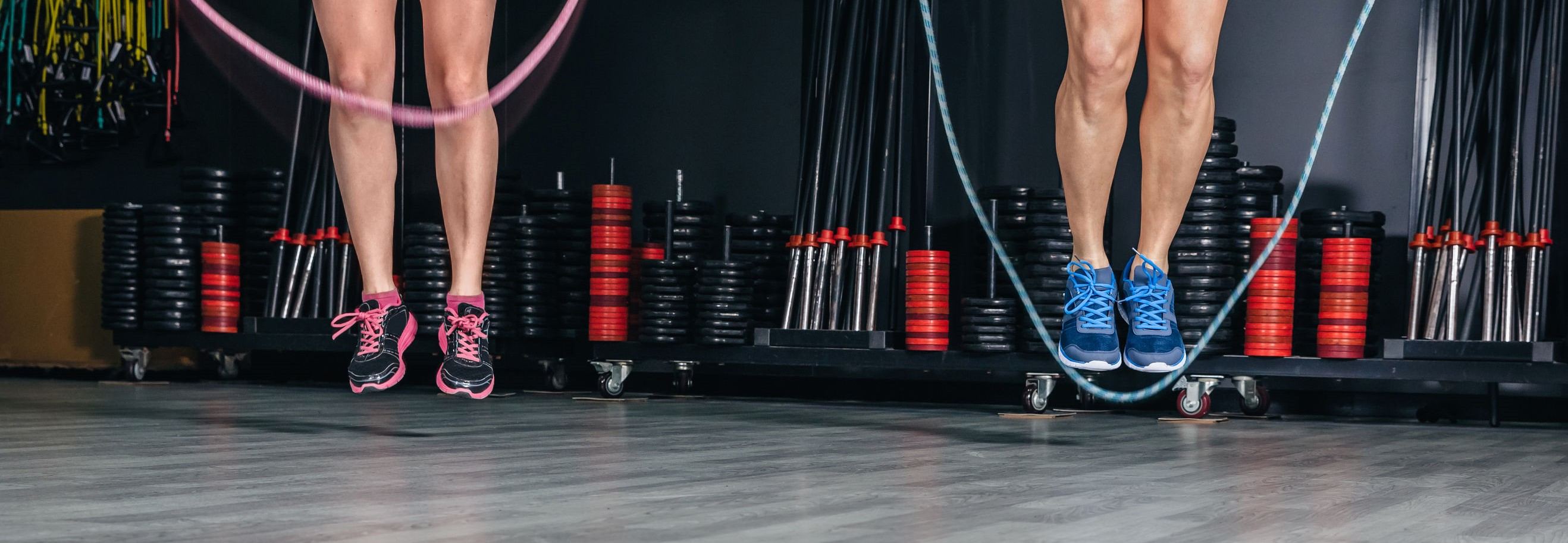 People legs doing exercises with jumping ropes in sports center