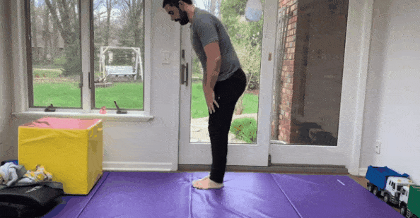 While standing, Coach Matt reaches for his toes, which is a great flexibility exercise.