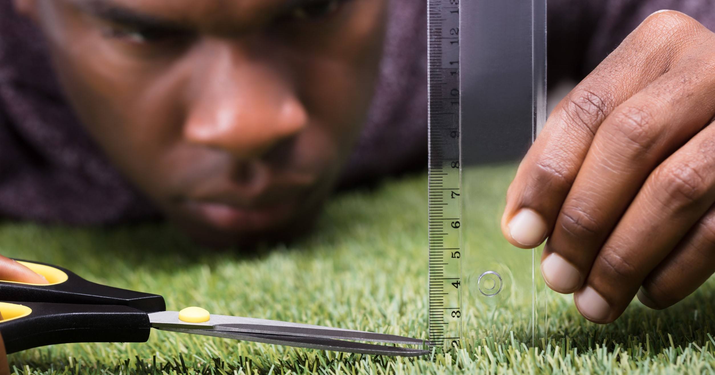 A pic of a man cutting grass, who might feel like an imposter if he doesn't.