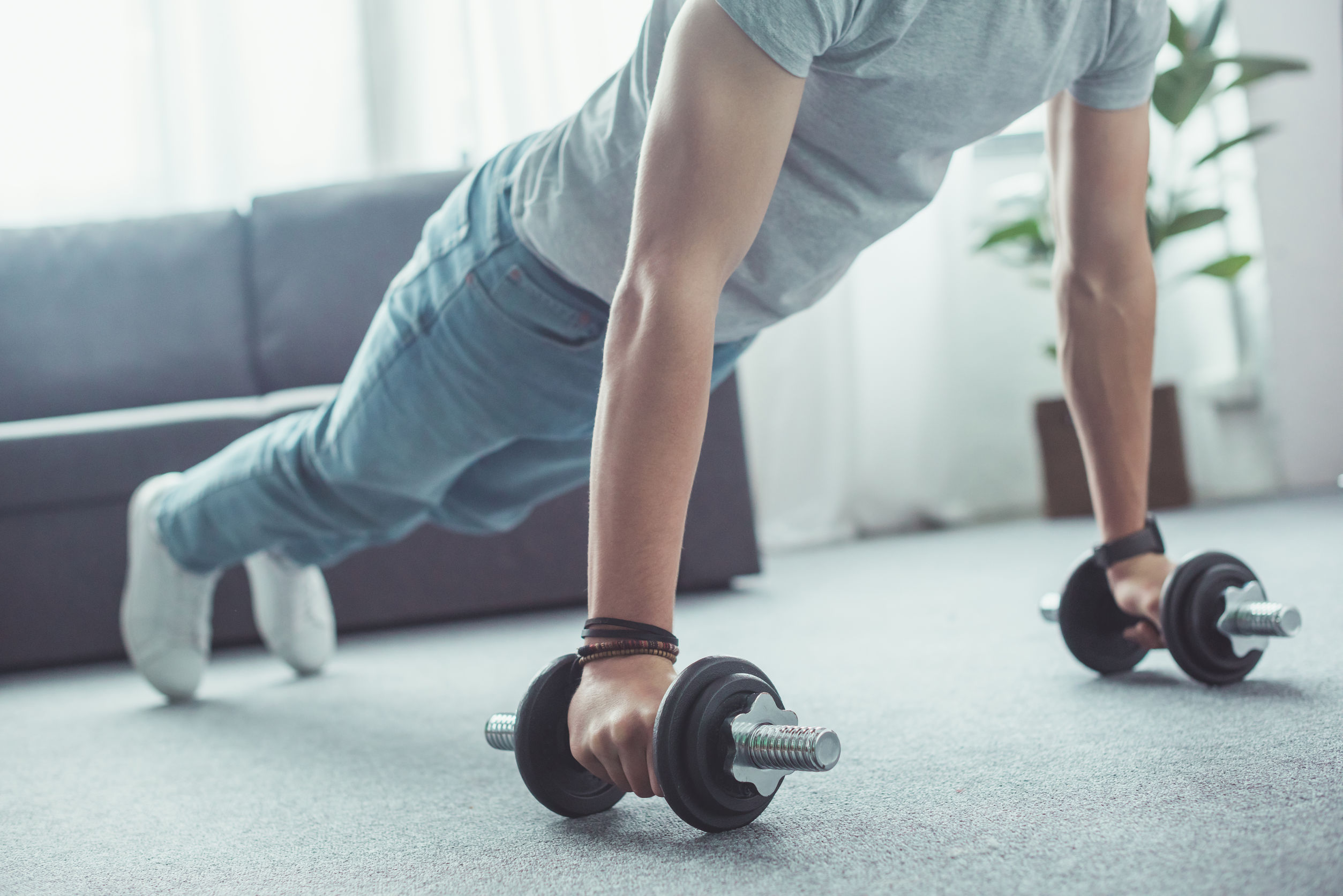 This picture shows a man with a couple weights, working out in a small space.