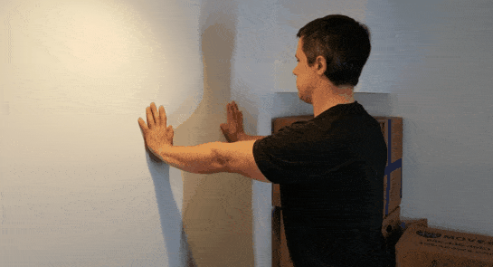 Coach Jim doing wall push-ups in a small space.