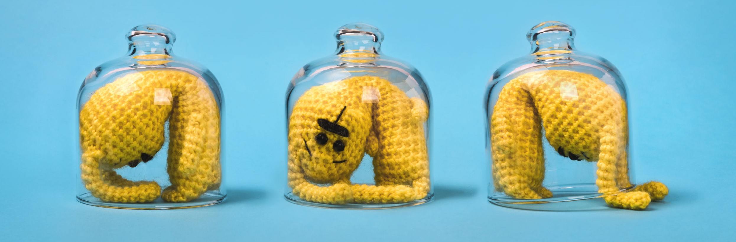 A picture of three figures trapped in a glass small space.