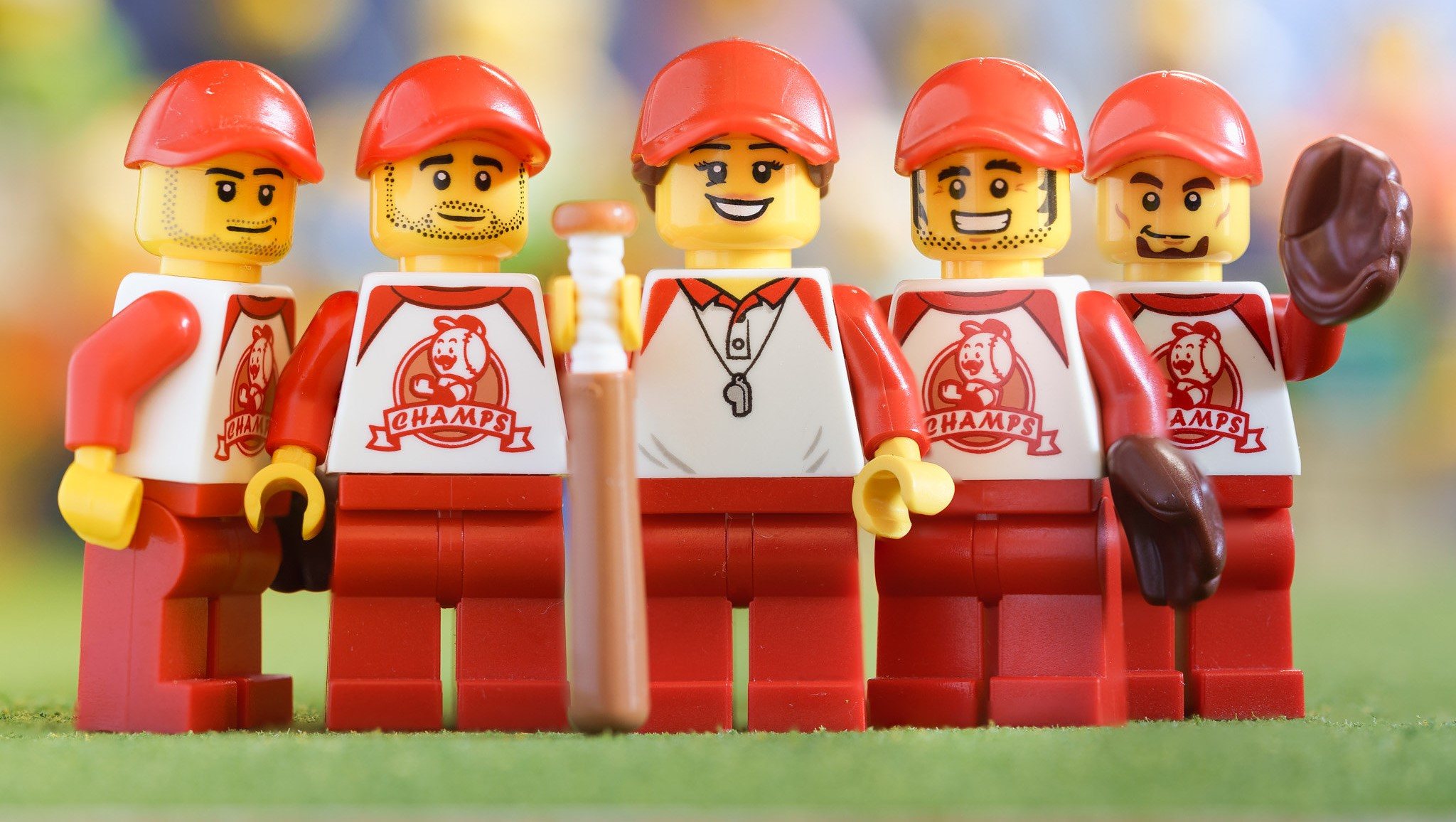 This photo shows five LEGO baseballs players smiling.