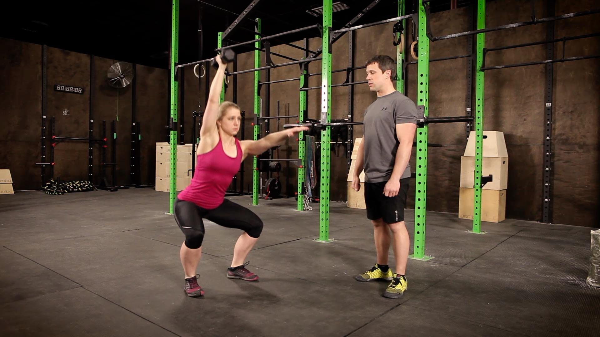 Coach Staci doing a overhead dumbbell squat
