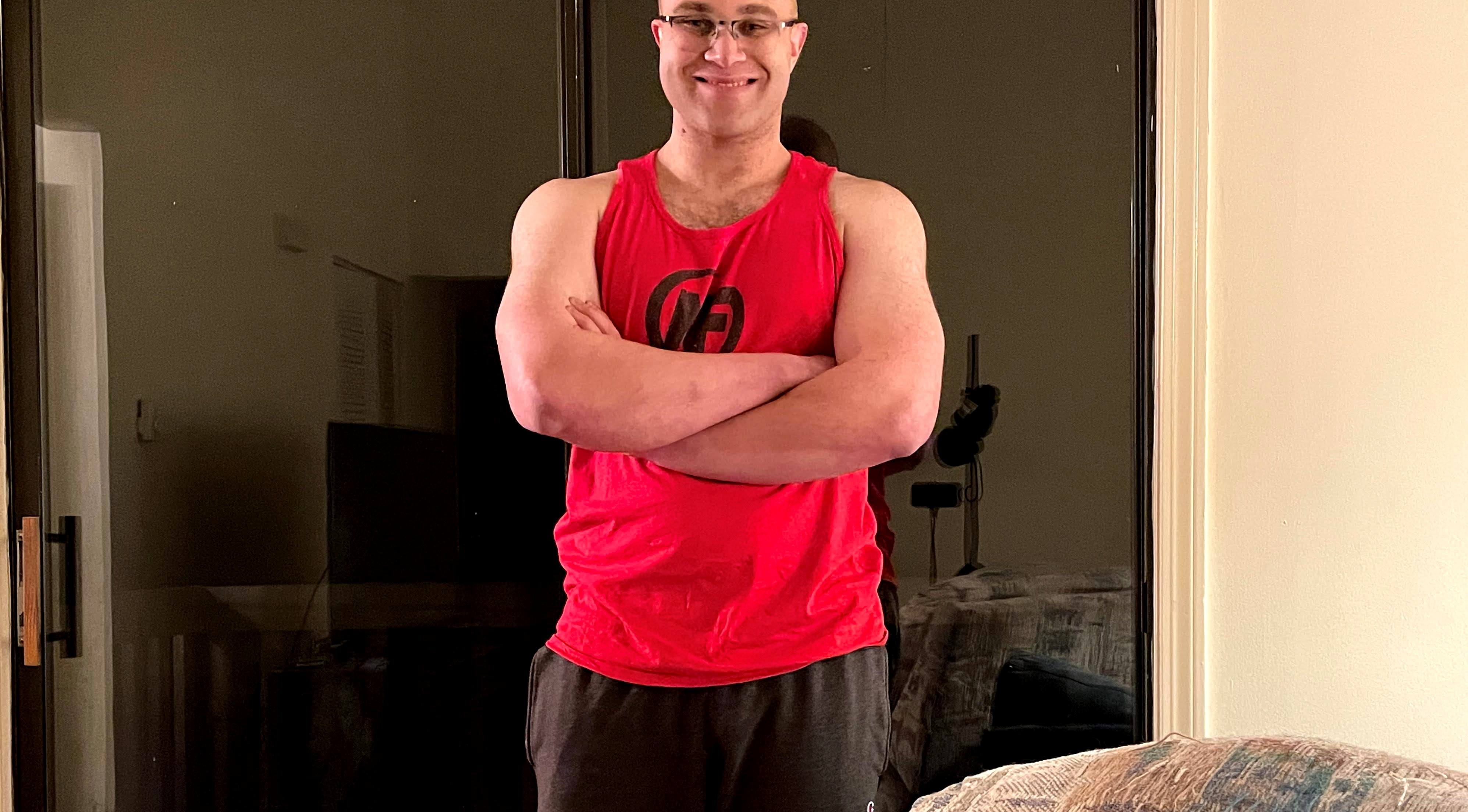 Brian smiling with arms folded across his chest wearing NF tank top