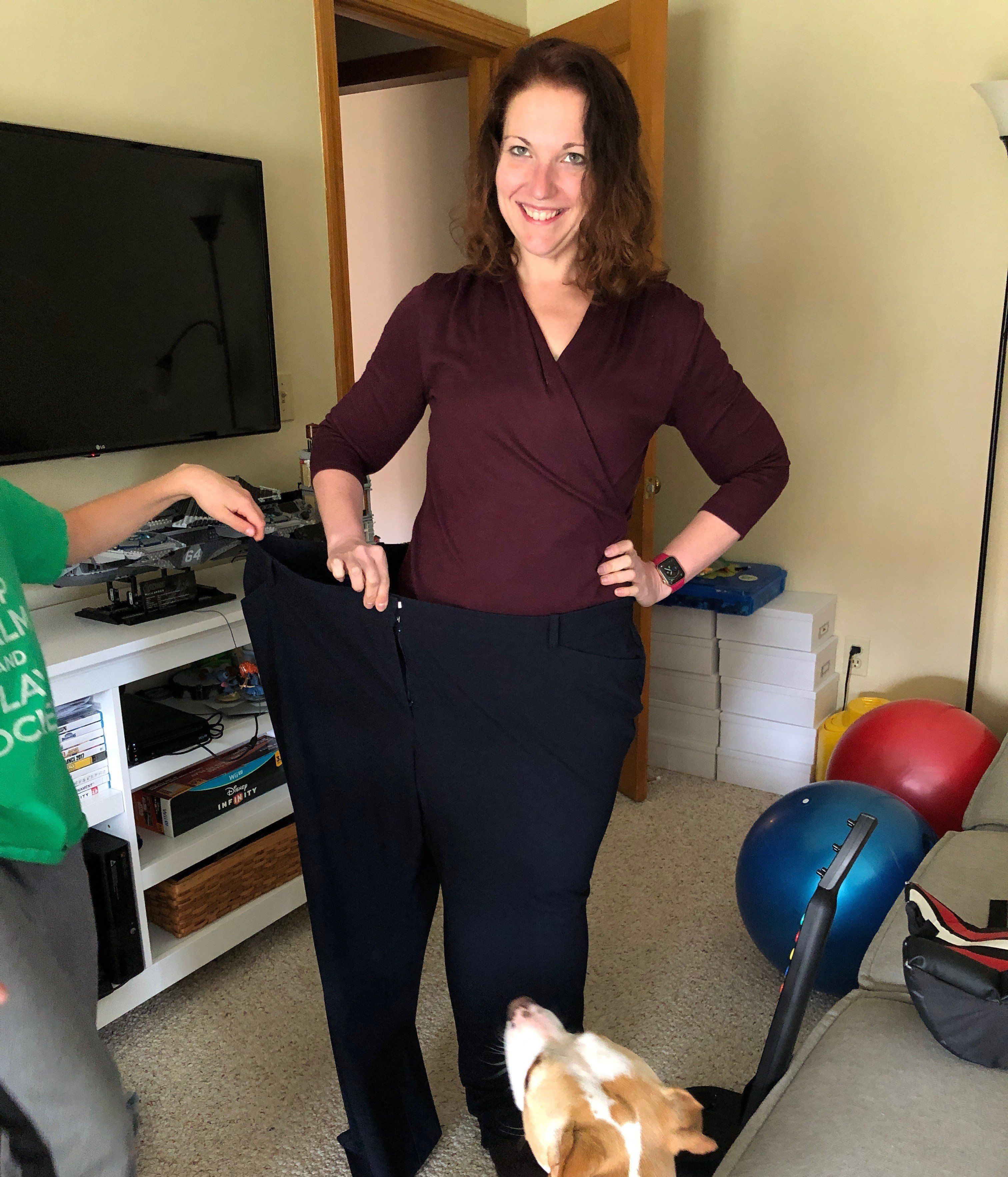 Megan standing in one leg of her old pants