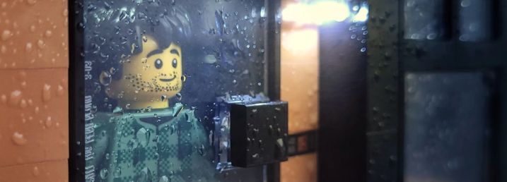 A Lego looking out the window of his home