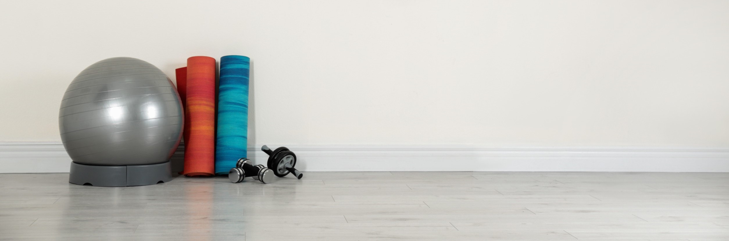 A bunch of fitness equipment against a wall.