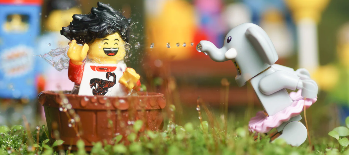 A LEGO being washed by an elephant