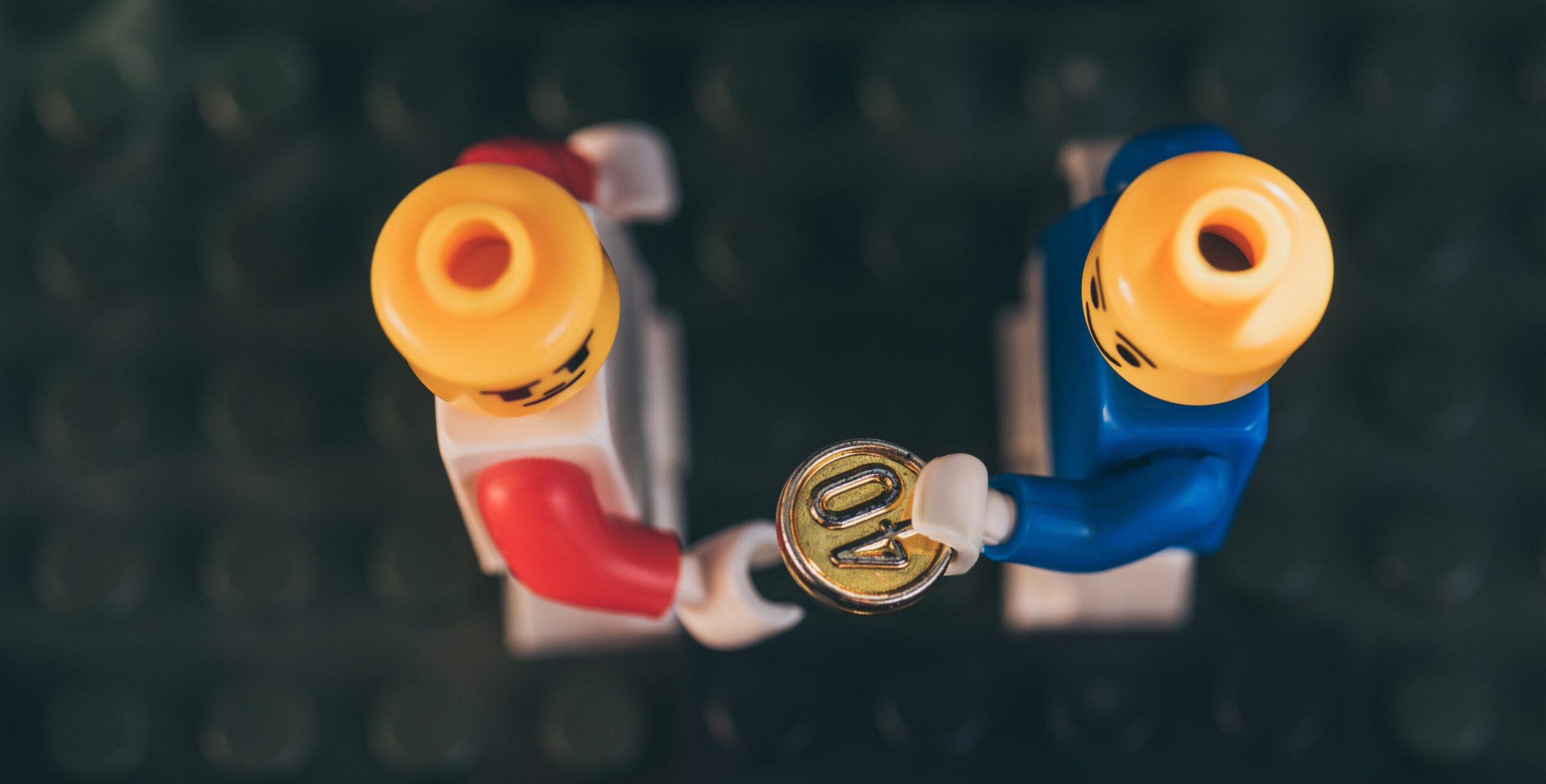Two LEGOs exchanging coins